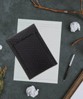 Black Padded Bubble Mailer Envelopes 12x18 on desk with stationery, ideal for small business packaging and mailing