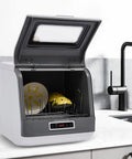 Compact Portable Countertop Dishwasher Featuring Three Wash Cycles And A Straight Up No Install Faucet Setup Super Darn Handy For Tiny Apartments And RVs fast clean kitchen saver with open lid and dishes inside.