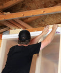 Person applying White Vapor Barrier Tape 9 Mil Thick, 3.78-Inch by 60-Yards Waterproof Moisture Barrier to construction wall.