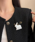 Absolute Fire Dangling Rabbit Safety Pin Lapel Brooch For Women And Men on a textured black jacket, with golden clasp.