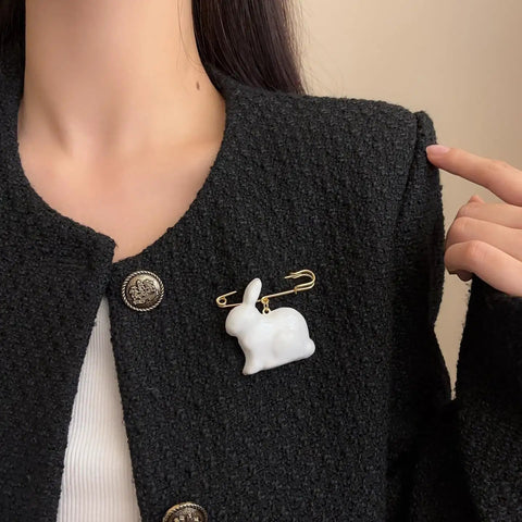 Absolute Fire Dangling Rabbit Safety Pin Lapel Brooch For Women And Men on a textured black jacket, with golden clasp.