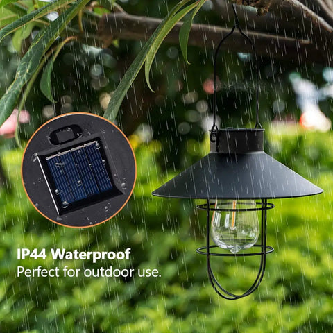 2 Pack Solar Metal Hanging Lanterns With Shepherd Hooks For Outdoor LED Garden Lighting Black Pathway Porch Yard Decor That Pops Durable Weatherproof Landscape Lights hanging from a tree branch in rain with solar panel insert