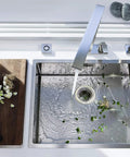 Stainless Steel Sink Strainer Basket 2.25 Inch Drain Hair Catcher 4 Pack For Kitchen installed in sink, cutting board nearby.