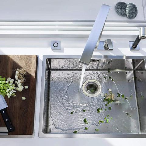 Stainless Steel Sink Strainer Basket 2.25 Inch Drain Hair Catcher 4 Pack For Kitchen installed in sink, cutting board nearby.