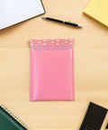 Pink Bubble Padded Mailers Self Seal Envelopes 100 Pack For Jewelry And Makeup Supplies on desk with stationery
