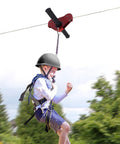Child using Backyard Zip Line Kit For Kids And Adults Up To 330 Lb, 120 Ft Stainless Steel Zip Line With Spring Brake, Safety Harness And Helmet