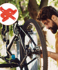 Mechanic using Eight-Piece Orange Bicycle Brake Pad Spacer Set for Hydraulic Disc Brakes on mountain bike outdoors.
