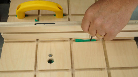 Hand adjusting MicroJig MatchFit Pop Stop 6-Pack: Pro Go-To Dovetail Track Stops on a woodworking jig with screwdriver