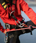 Person using Lightweight 35kN Aluminum Figure 8 Descender Rigging Plate Red 2 Pack For Rappel And Climbing in outdoor setting