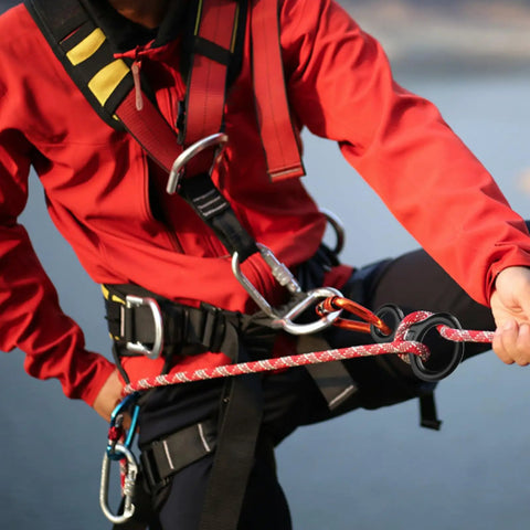 Person using Lightweight 35kN Aluminum Figure 8 Descender Rigging Plate Red 2 Pack For Rappel And Climbing in outdoor setting