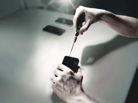 Using Kraftform Kompakt Micro 11 Universal Precision Screwdriver Set to work on delicate electronics, showing anti-roll handle and control.