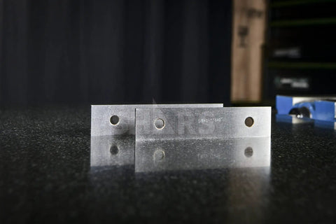 Close-up of One Eighth Inch Precision Steel Parallels, 6 Inch Long, 10 Pair Set, Ground And Hardened on a reflective surface