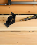 Heavy Duty Folding Leg Connectors With Wearproof Iron Coating for Hidden Furniture Hinges next to a screwdriver on a wooden surface.