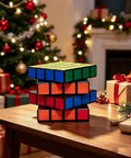 Stack of colorful Rubik's cubes on wooden table with Christmas decorations and gifts in background