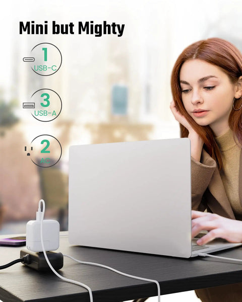 Woman using laptop connected to Six In One Charging Station With USB C And USB A Ports, Two Wide Spaced 110V Outlets, 5 Ft Cord, Black