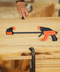Heavy Duty Woodworking Bar Clamps With Quick Release on wooden workbench, featuring steel construction and TPR jaws, no screwdriver needed.
