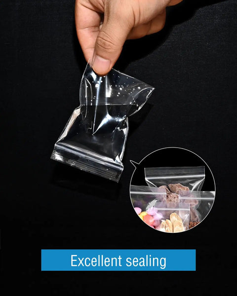 Hand holding small clear resealable plastic bag with excellent sealing, part of 500 Pack Small Clear Resealable Plastic Bags With Four Size Options For Jewelry Candy Pills And More, Durable Reusable Poly Bags For Packaging Storage And Organization Grab And Go Ready.