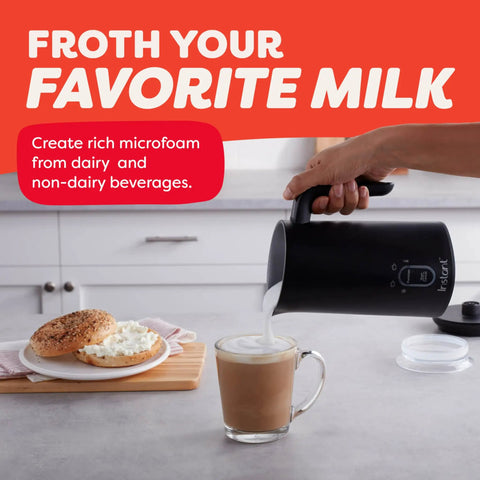 Pouring milk from 4 In 1 Electric Milk Frother And Steamer With 10oz Capacity into a glass on kitchen counter, black color.