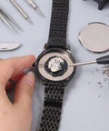 Straight Up Premium Watch Battery Clamp Screws Assortment Kit on wristwatch during repair with tools and screws visible.