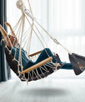 Person sitting on Patio Swing Chair With Adjustable Footrest And Headrest For A Comfy Cloudlike Sit Quilted Fabric And Steel Spreader Bar Wooden Armrests For Porch Or Garden 350 Lb Capacity Hardware Kit Included 2025 Upgrade indoors