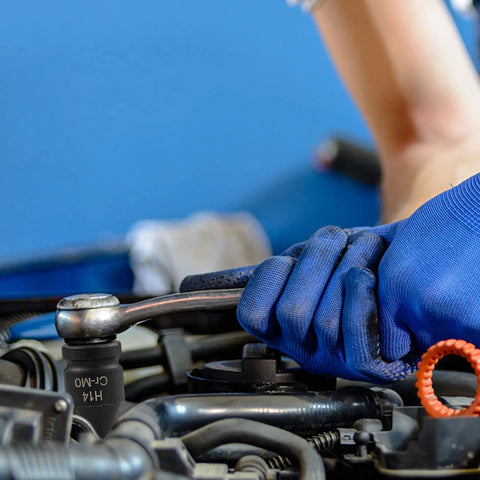 Mechanic using a 1/2" drive from the Twenty Piece One Half Inch Drive Master Impact Allen Hex Bit Set on an automotive engine.