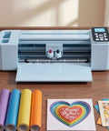 Level Up Your Side Hustle With This Slick 12 Inch Vinyl Cutting Machine on a wooden table with colored vinyl rolls and cards.