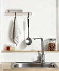 No Drill Self Adhesive Towel Holder 9 Inch Stainless Steel Bar In Brushed Gold Finish over a kitchen sink with a towel