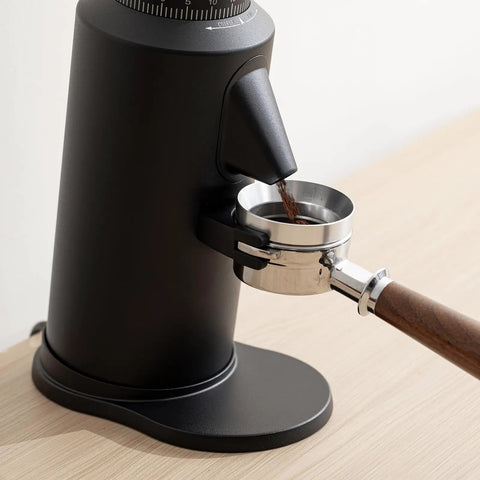 Dope Single Dose Electric Coffee Grinder Featuring 64Mm Titanium Flat Burrs And Stepless Adjustment To Nail Your Flavor Packed Espresso Routine In Sleek Black Finish with coffee grounds funneling into portafilter.