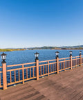 Outdoor Solar Powered Post Cap Lights For 4x4 Wood Posts, lining a wooden deck rail by a lake, Classic Lantern Style, Black