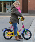 Child with pink bicycle featuring colorful 180 Pcs Spoke Covers Set For Bikes And Dirt Bikes, 10 Color Variety, Durable Plastic Rim Wraps