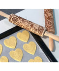 Rose Embossed Rolling Pin For Baking Cookies And Shortbread With Flower Pattern, Wooden Engraved Springerle Style Rolling Pin For Clay Pottery Ceramics, Deep Embossed Texture For Clear Impressions, shown with heart-shaped cookie dough on a baking tray.