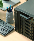 Powerhouse 10 Bay Network Attached Storage on desk with keyboard and plant, showcasing 2.1GHz Quad Core, NVMe cache slots, dual 10GbE ports.