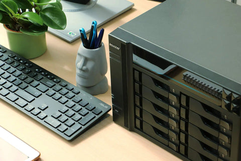 Powerhouse 10 Bay Network Attached Storage on desk with keyboard and plant, showcasing 2.1GHz Quad Core, NVMe cache slots, dual 10GbE ports.