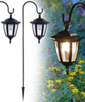 Solar Hanging Lights For Outdoors, 2 Pack With 38 Inch Shepherd Hooks over garden, 3000K warm white LED glow illuminating flowers.