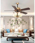 Slick Five Blade Vintage Gold Ceiling Fan With Six Frosted Milk Glass Lights And Rugged Dark Wood Blades For Hella Cozy Farmhouse Vibe Featuring Whisper Quiet Motors And Swanky Lantern Chandelier Setup in a modern living room.