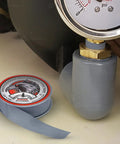 Pro Grade PTFE Thread Seal Tape For Plumbers White Gray Three Quarter Inch By Five Hundred Twenty Inches Pack Of Ten Rolls Leak Proof Easy To Apply Universal Pipe Thread Sealant For All Fittings Home Commercial Industrial Plumbing next to a gauge and pipe fitting.