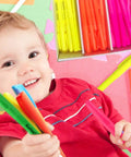 Child holding Chisel Tip Highlighters 96 Count Bulk Pack Assorted Fluorescent Colors No Bleed Through Smudge Proof in playroom