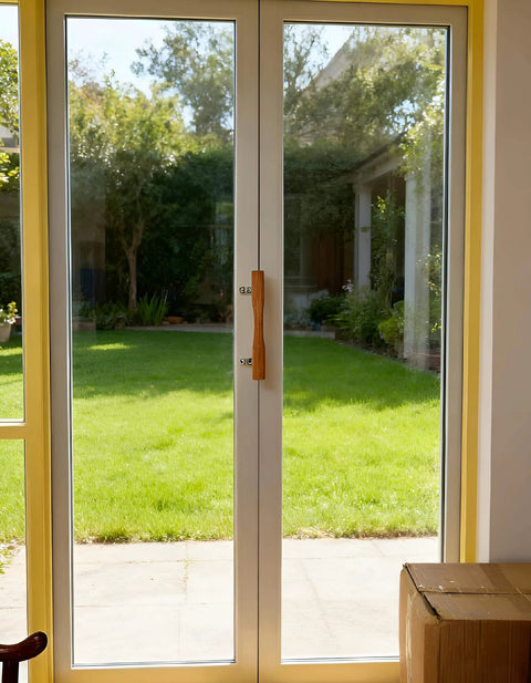 Natural Solid Wood Sliding Patio Door Handle With Ergonomic Curved Grip installed on glass door with chrome brackets.