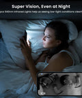 Woman in bed using phone with Upgrade 2K WiFi Indoor Security Camera displaying baby monitor, night vision active.