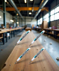 Three Heavy Hitter White Oil Based Permanent Markers Pro Grade Industrial Pens on a wooden workbench in a workshop.