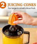 Elite Gourmet Citrus Juicer 1.2 L Capacity Black And Stainless Steel Electric Orange Lemon Squeezer with dual juicing cones in use.