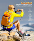 Woman charging devices on rocky terrain with 42800mAh Solar Charger Power Bank Portable Charger With USB C Input Output Dual USB Ports QC 3.0.