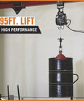 Bannon Compact Electric Cable Hoist 1100 Lb Capacity 95ft Lift lifting a black drum with galvanized rope and saddle hook.