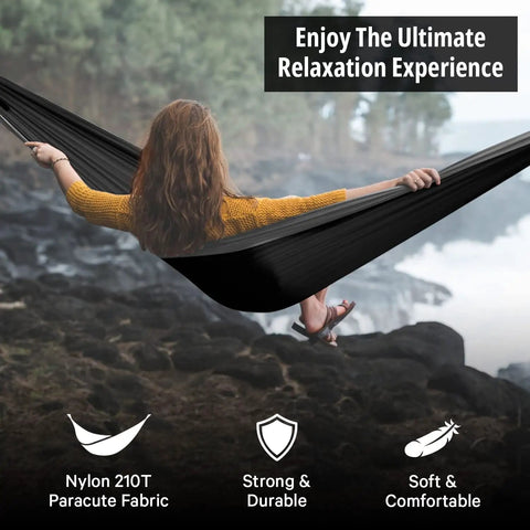 Woman relaxing in Durable Nylon Camping Hammock For Outdoors, set up by a river, enjoying nature, made from Nylon 210T fabric.