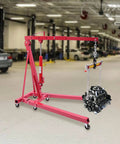 Heavy Duty Two Ton Foldable Engine Hoist With Adjustable Cherry Picker Crane Boom and Six Tight Turning Casters in garage setting.