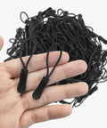 Hand holding two black zipper pulls from 20 Piece Zipper Pull Replacement Kit For Jackets Luggage And Backpacks Black Zipper Pull Tabs For Repair