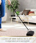 Electrostatic Carpet And Floor Sweeper Boasts A Nine Inch Cleaning Path For Tile And Rug, in use on a rug, matte black design.