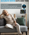 Ultimate Wireless Weather Station With Indoor And Outdoor Temperature And Humidity Readouts Atomic Clock Barometric Pressure Forecast USB Port Four Sensor Zones And A Big Easy To Read Display For Home Office Bedroom displayed on a table behind a relaxed woman in a living room setting.