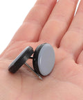 Hand holding two 12 Piece Nail On Chair Leg Sliders For Hardwood Floors Heavy Duty Plastic And Metal Floor Protectors Easy Install.