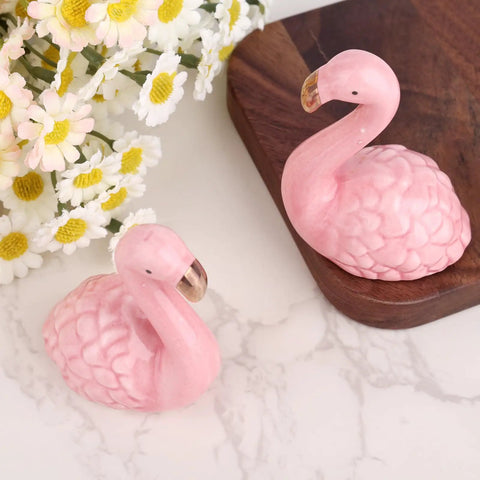 Totally Vibes Super Sweet Pink Flamingo Ceramic Toilet Bolt Covers Sets Off That Nice Vibe In Any Bathroom Super Easy Install Waterproof Flange Caps For A Fast Home Glow Up Two Pack displayed with flowers.